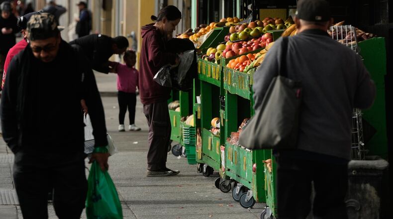 A person shops for produce at a market in San Francisco on Saturday, Nov. 15, 2025. (AP Photo/Jeff Chiu)