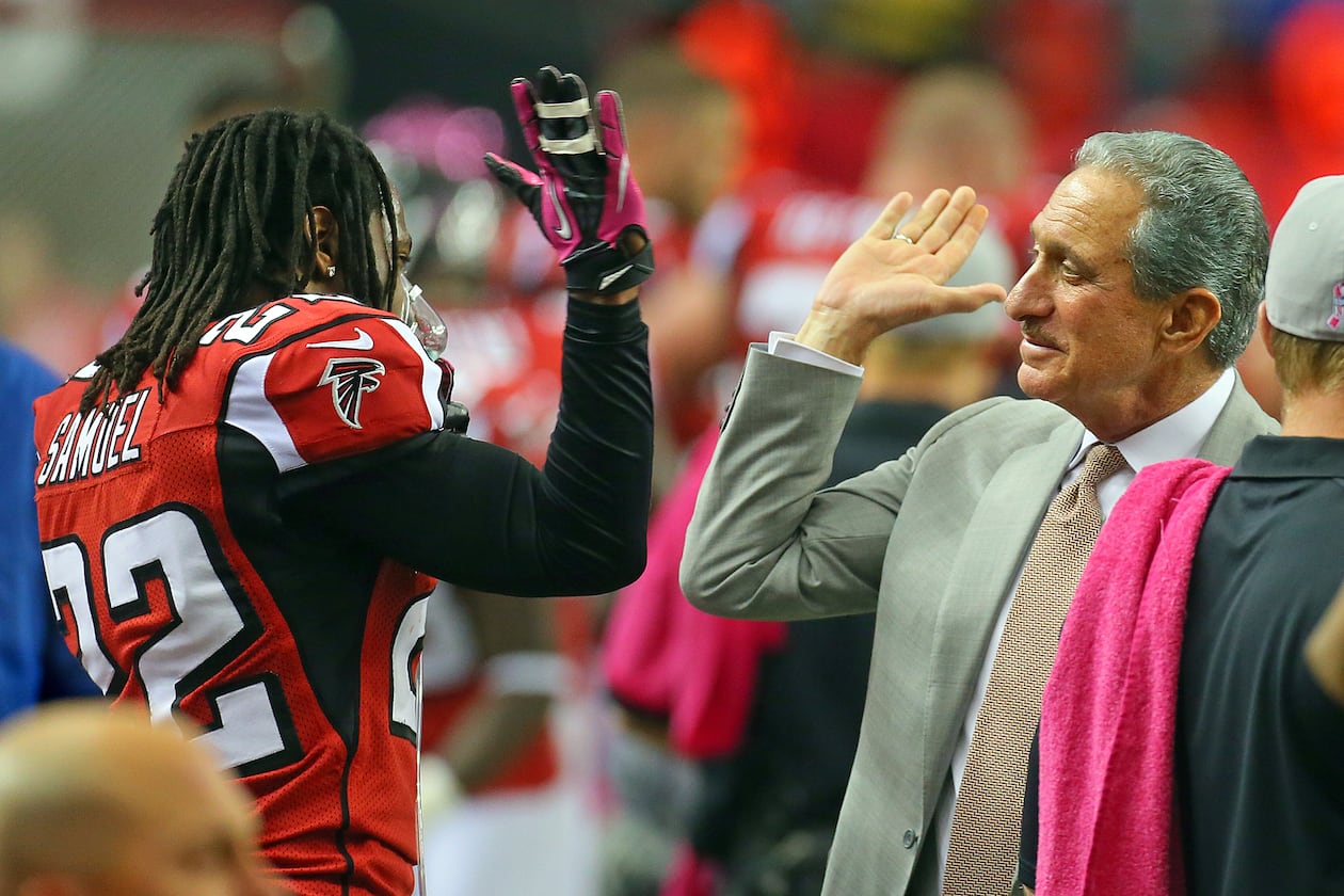 Falcons owner Arthur Blank gives cornerback Asante Samuel a high five on the sidelines. (Curtis Compton/AJC File)