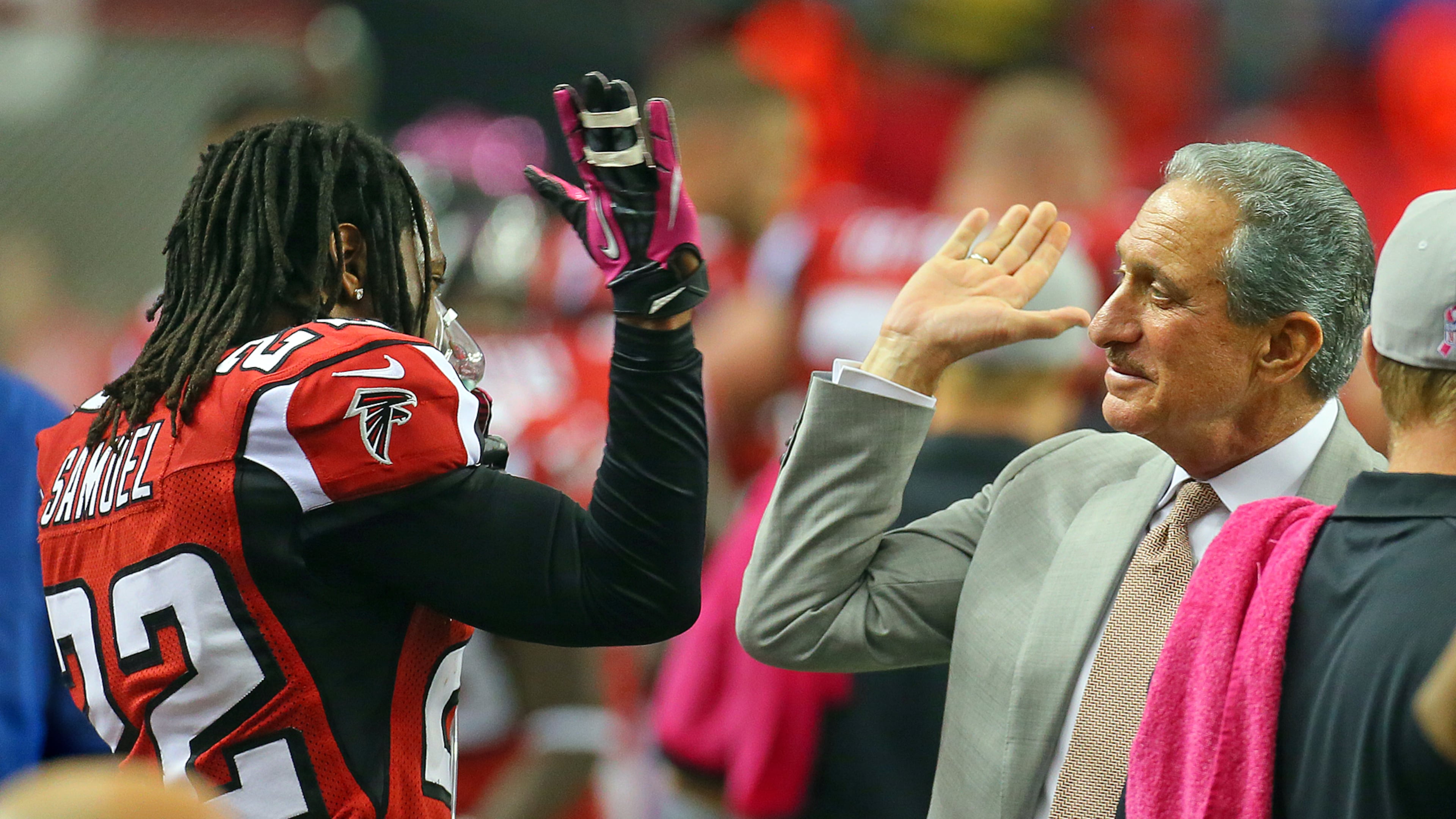 Falcons owner Arthur Blank gives cornerback Asante Samuel a high five on the sidelines. (Curtis Compton/AJC File)