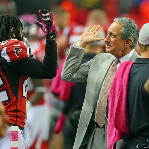 Falcons owner Arthur Blank gives cornerback Asante Samuel a high five on the sidelines. (Curtis Compton/AJC File)