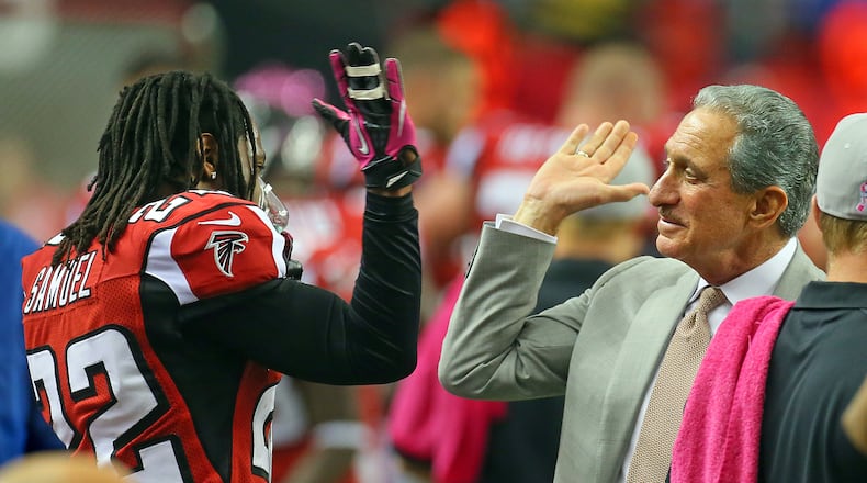 Falcons owner Arthur Blank gives cornerback Asante Samuel a high five on the sidelines. (Curtis Compton/AJC File)