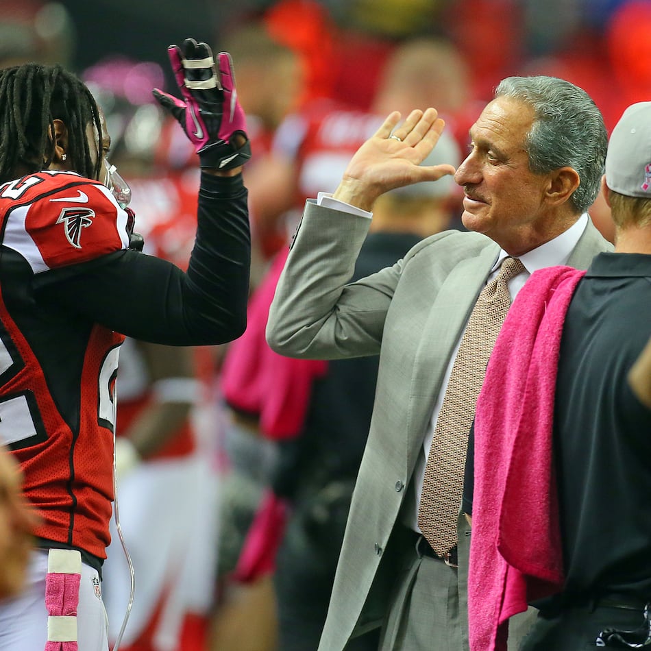 Falcons owner Arthur Blank gives cornerback Asante Samuel a high five on the sidelines. (Curtis Compton/AJC File)