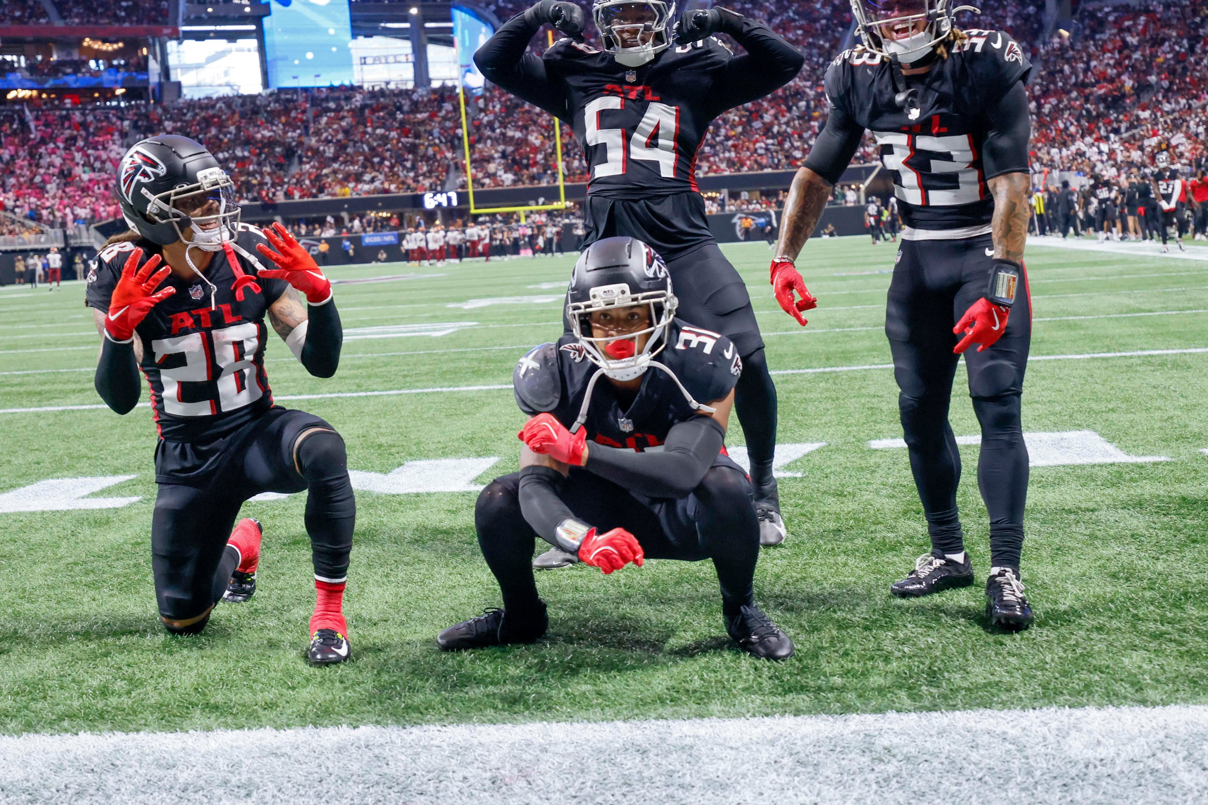 Atlanta Falcons safety Xavier Watts (bottom center) celebrates with teammates after his interception during the second half of an NFL game against the Washington Commanders at Mercedes-Benz Stadium in Atlanta on Sunday, September 28, 2025. (Miguel Martinez/AJC)