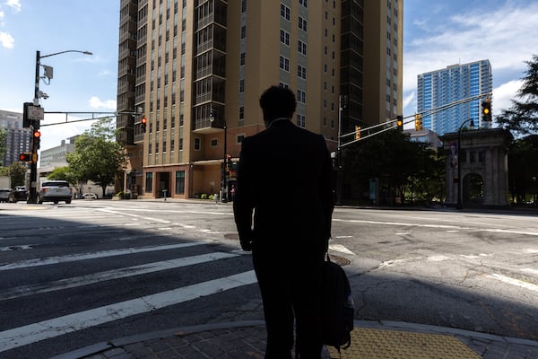 A pedestrian stands on the crosswalk at the intersection of Peachtree and Baker streets in Atlanta on Tuesday. Local leaders recently have increased calls for safety upgrades throughout the city after a string of downtown pedestrian fatalities. (Arvin Temkar/AJC)
