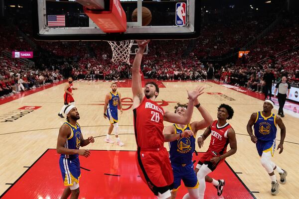 Houston Rockets center Alperen Sengun (28) shoots agasint Golden State Warriors guard Brandin Podziemski (2) during the first half of Game 1 of an NBA basketball first-round playoff series in Houston, Sunday, April 20, 2025. (AP Photo/Ashley Landis)