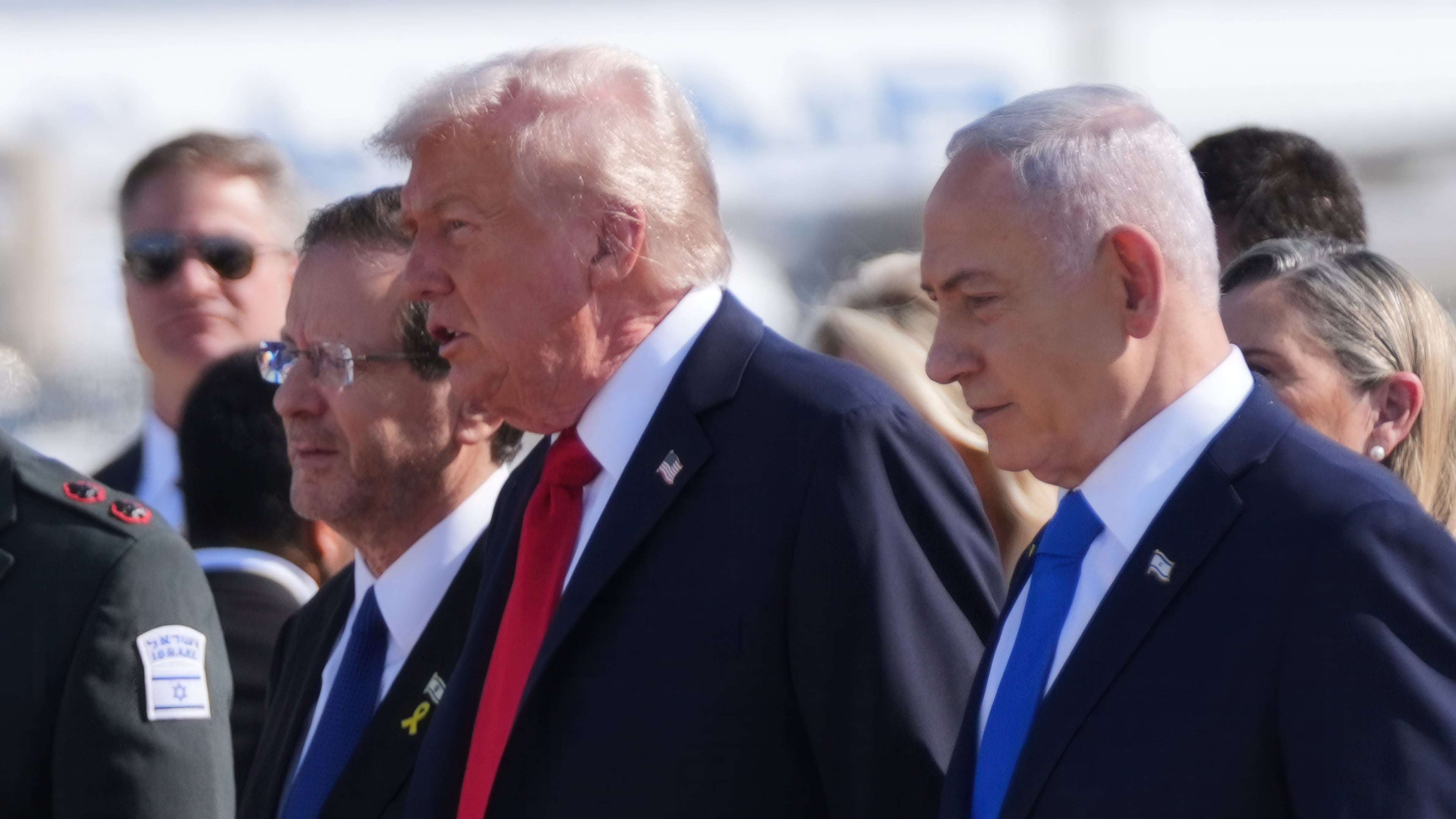 President Donald Trump walks with Israel's President Isaac Herzog, left, and Israel's Prime Minister Benjamin Netanyahu during an arrival ceremony at Ben Gurion International Airport, Monday, Oct. 13, 2025, near Tel Aviv. (AP Photo/Evan Vucci)