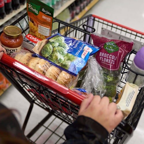 FILE - A California's SNAP benefits shopper pushes a cart through a supermarket in Bellflower, Calif., Feb. 13, 2023. (AP Photo/Allison Dinner, File)