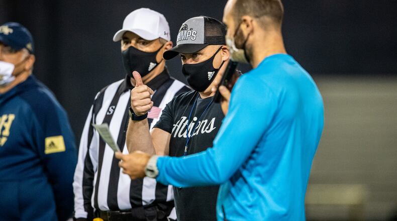 Tech coach Geoff Collins (third from left) chats with director of football operations Scott Wallace at practice Tuesday morning. Photo by Danny Karnik/Georgia Tech Athletics