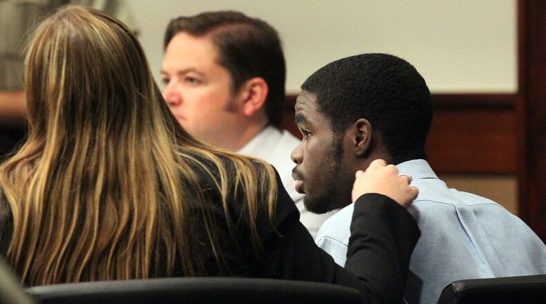 A member of the defense team put her hand on De'Marquise Elkins' shoulder as he was found guilty of all charges at the Brunswick baby murder trial in Cobb Superior Court in Marietta on Friday, August 30, 2013.