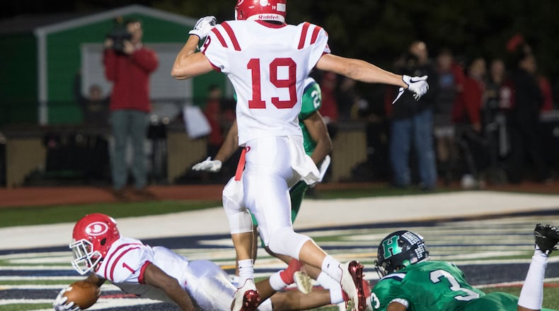 Dalton running back Jahmyr Gibbs (1) scores with Harrison cornerback Marquis Alston (3) on the ground and Chandler Starks (19) following behind during a high school football game on Thursday, Oct. 19, 2017, in Kennesaw, Ga. (Special to the Atlanta Journal-Constitution, John Amis )