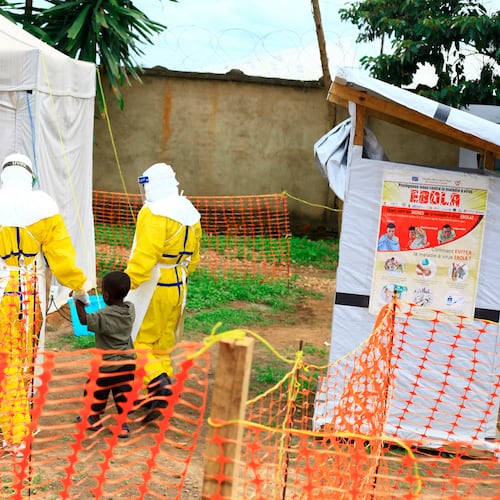 FILE - Health workers walk with a boy suspected of having the Ebola virus at an Ebola treatment center in Beni, eastern Congo, Sept 9, 2018. (AP Photo/Al-hadji Kudra Maliro, File)