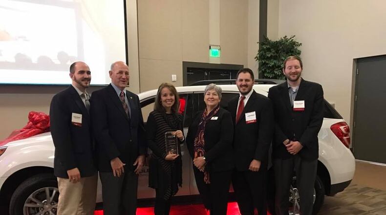 Forsyth county teacher Maleah Stewart (pictured with plaque) poses with school district officials after winning 2017 teacher of the year honors.