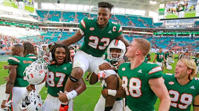 Miami Hurricanes tight end Christopher Herndon IV (23) is carried off by teammates after the University of Miami Hurricanes defeated the Virginia Cavaliers at Hard Rock Stadium on Saturday, Nov. 18, 2017 in Miami. The Hurricanes won 44-28. (Al Diaz/Miami Herald/TNS)