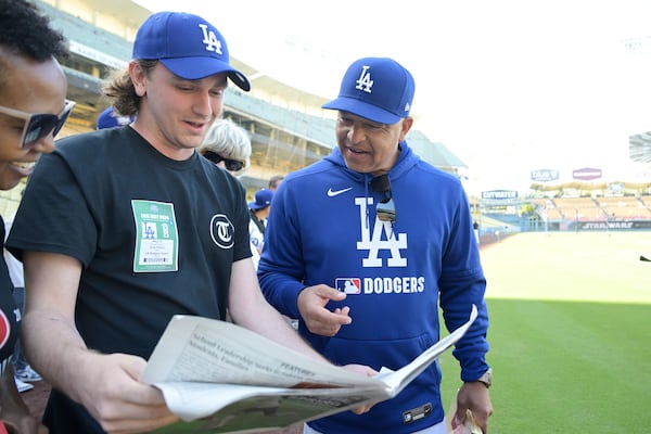 Samuel O'Neal, left, editor-in-chief of Temple News, shows a copy of his school's publication to Los Angeles Dodgers manager Dave Roberts during a visit to Dodger Stadium, Wednesday, May 14, 2025, in Los Angeles. AP Photo/Jayne Kamin-Oncea)