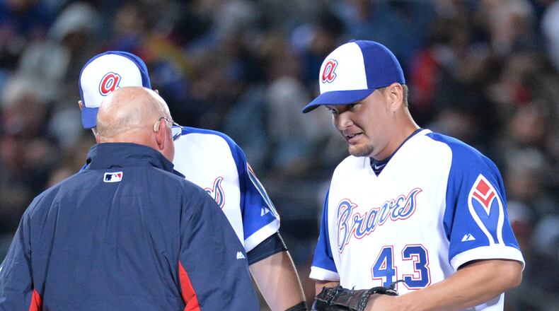 Atlanta Braves pitcher Luis Avilan is injured and checked by medical staff in the 7th inning of the season opener at Turner Field in Atlanta on Tuesday, April 8, 2014. New York Mets won 4-0 over the Atlanta Braves. HYOSUB SHIN / HSHIN@AJC.COM