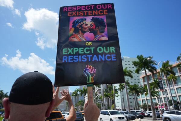 A person holds a sign in support of gay rights during a protest against the Trump administration, Saturday, April 19, 2025, in Miami. (AP Photo/Lynne Sladky)