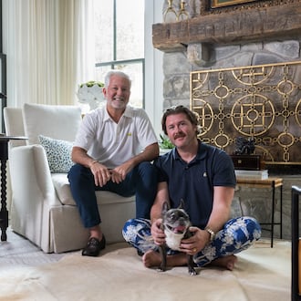 Clinton Rice and Michael Mock — and French bulldog Rose — in the antiques-filled living room of their Serenbe home. (Tomas Espinoza for the AJC)