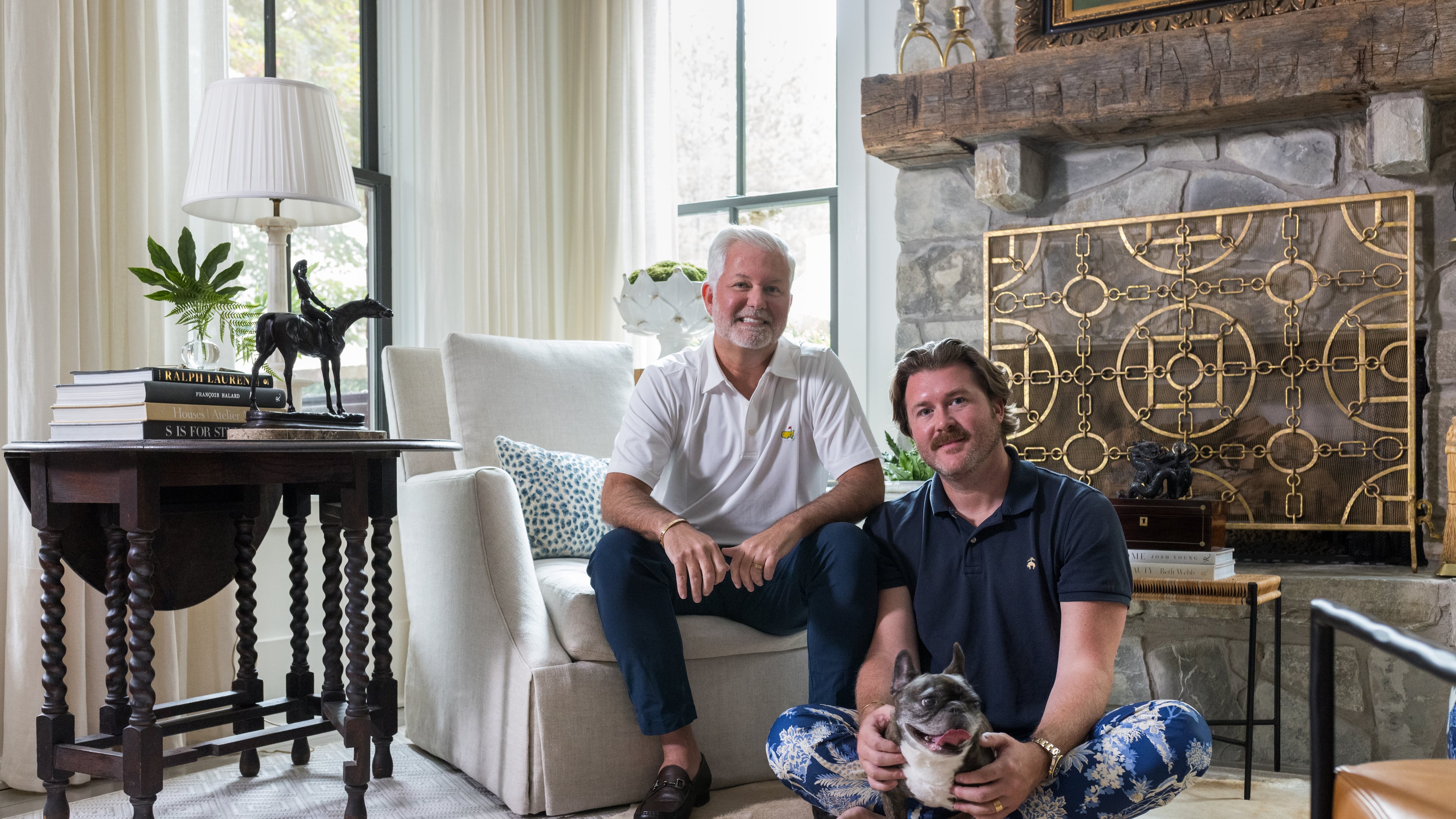 Clinton Rice and Michael Mock — and French bulldog Rose — in the antiques-filled living room of their Serenbe home. (Tomas Espinoza for the AJC)