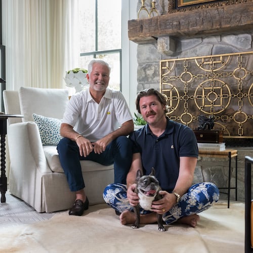 Clinton Rice and Michael Mock — and French bulldog Rose — in the antiques-filled living room of their Serenbe home. (Tomas Espinoza for the AJC)