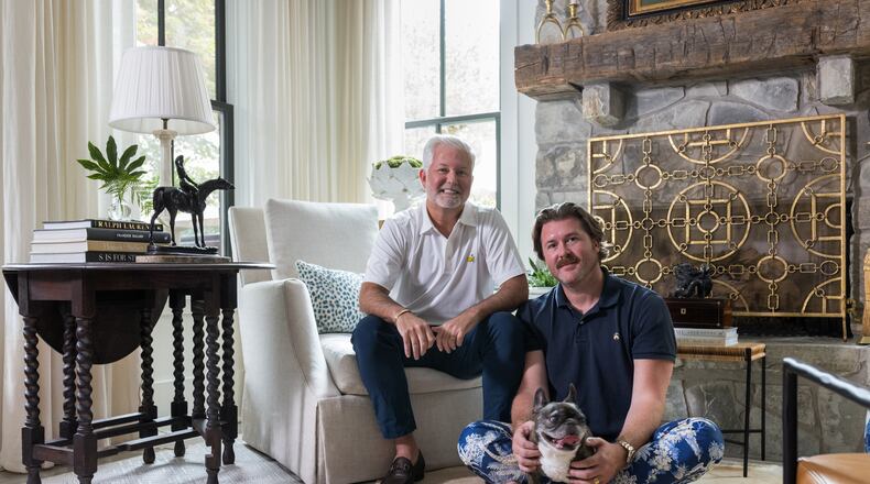 Clinton Rice and Michael Mock — and French bulldog Rose — in the antiques-filled living room of their Serenbe home. (Tomas Espinoza for the AJC)