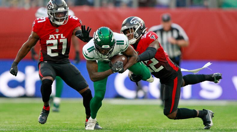 New York Jets wide receiver Denzel Mims (11) is tackled by Falcons safety Richie Grant (27) and safety Jaylinn Hawkins (32) during the second half Sunday, Oct. 10, 2021, at the Tottenham Hotspur stadium in London. (Ian Walton/AP)