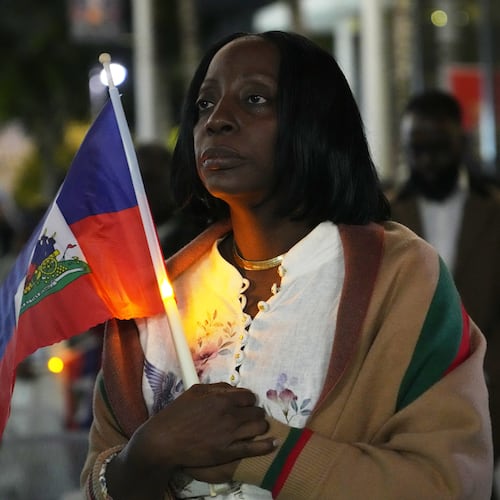 FILE - Linda Joseph holds a candle during a vigil at the Little Haiti Cultural Complex after a federal judge blocked the Trump administration from ending temporary immigration status, or TPS, for Haitians, Tuesday, Feb. 3, 2026, in North Miami. (AP Photo/Lynne Sladky, File)