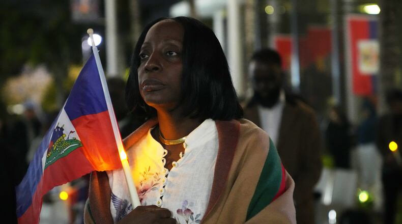 FILE - Linda Joseph holds a candle during a vigil at the Little Haiti Cultural Complex after a federal judge blocked the Trump administration from ending temporary immigration status, or TPS, for Haitians, Tuesday, Feb. 3, 2026, in North Miami. (AP Photo/Lynne Sladky, File)