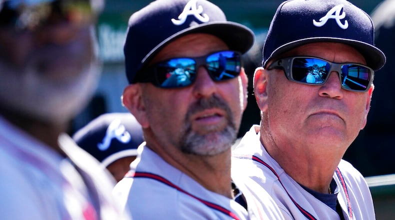 Atlanta Braves manager Brian Snitker, right, bench coach Walt Weiss, center, and first base coach Eric Young Sr., react as they watch after Chicago Cubs' Rafael Ortega hit a solo home run during the seventh inning of a baseball game in Chicago, Saturday, June 18, 2022. (AP Photo/Nam Y. Huh)