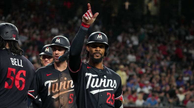 Minnesota Twins' Byron Buxton (25) celebrates after hitting a grand slam with teammates Josh Bell (56) and Ryan Kreidler (5) in the fifth inning of a baseball game against Arizona Diamondbacks Saturday, June 20, 2026, in Phoenix. (AP Photo/Darryl Webb)