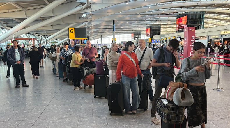 Passengers wait in line at Heathrow Airport in London, during an air traffic control problem that disrupted travel across Britain. (Jonathan Brady/PA via AP)
