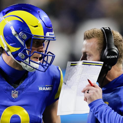 Los Angeles Rams head coach Sean McVay talks with quarterback Matthew Stafford, left, during the first half of an NFL football game Thursday, Dec. 18, 2025, in Seattle. (AP Photo/John Froschauer)