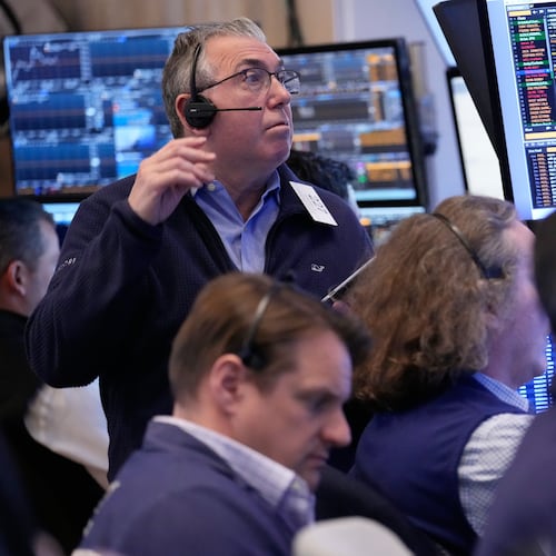 John Bishop, left, and others work on the floor at the New York Stock Exchange in New York, Monday, April 13, 2026. (AP Photo/Seth Wenig)