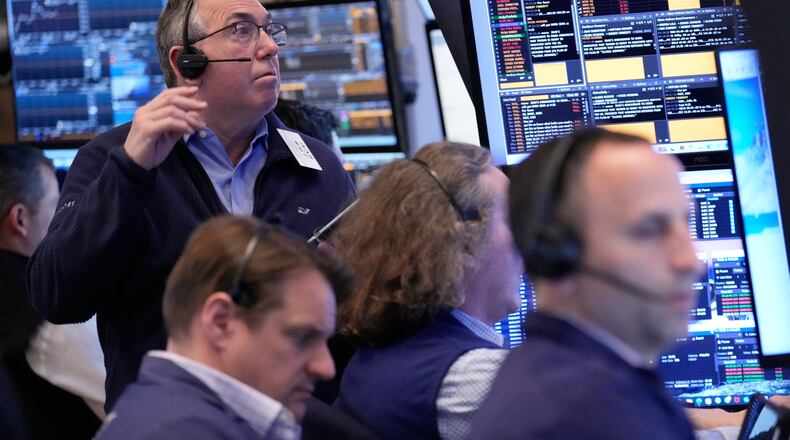 John Bishop, left, and others work on the floor at the New York Stock Exchange in New York, Monday, April 13, 2026. (AP Photo/Seth Wenig)