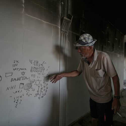 A Lebanese man points to Hebrew writing left by Israeli soldiers inside his destroyed home in the village of Zawtar al-Gharbieh, southern Lebanon, Wednesday, Aug. 5, 2026.(AP Photo/Mohammed Zaatari)