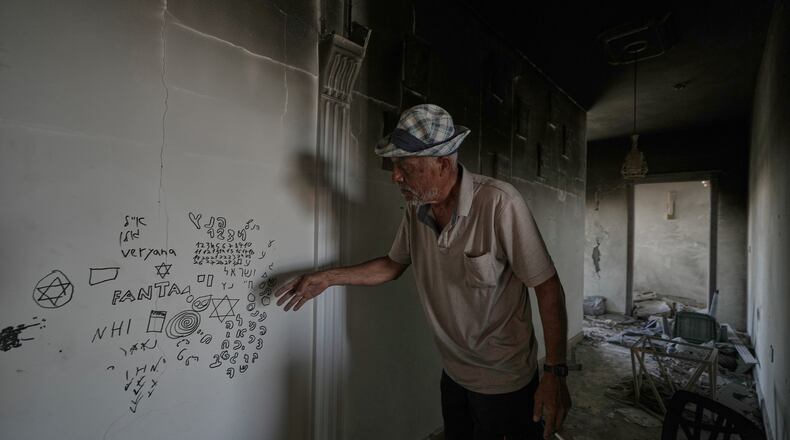 A Lebanese man points to Hebrew writing left by Israeli soldiers inside his destroyed home in the village of Zawtar al-Gharbieh, southern Lebanon, Wednesday, Aug. 5, 2026.(AP Photo/Mohammed Zaatari)