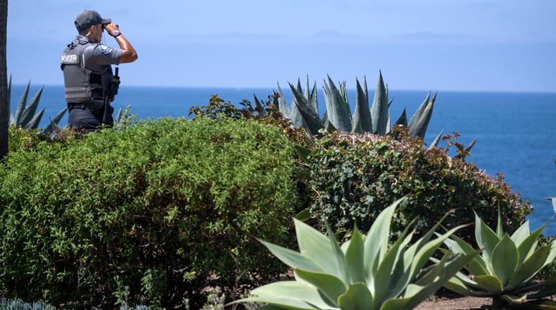 A Park Ranger scans the horizon on Wednesday, June 10, 2026, on Laguna Beach, Calif., near where a child was swept out to sea Tuesday. (Mindy Schauer/The Orange County Register via AP)
