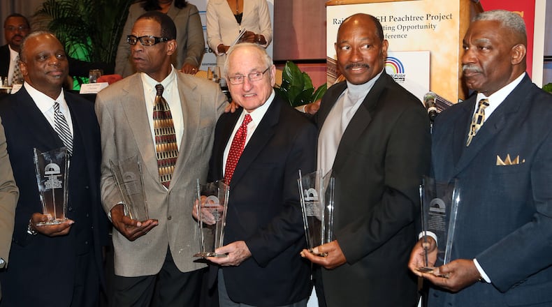 Former Georgia coach Vince Dooley (center) presents Larry West (from left), Richard Appleby, Horace King and Clarence Pope awards from the Rainbow PUSH Coalition honoring them for in 1971 becoming the first black students to play football on scholarship at the institution Saturday, Bo. 2, 2013, at the Hyatt Regency in Atlanta.  (Phil Skinner/AJC)