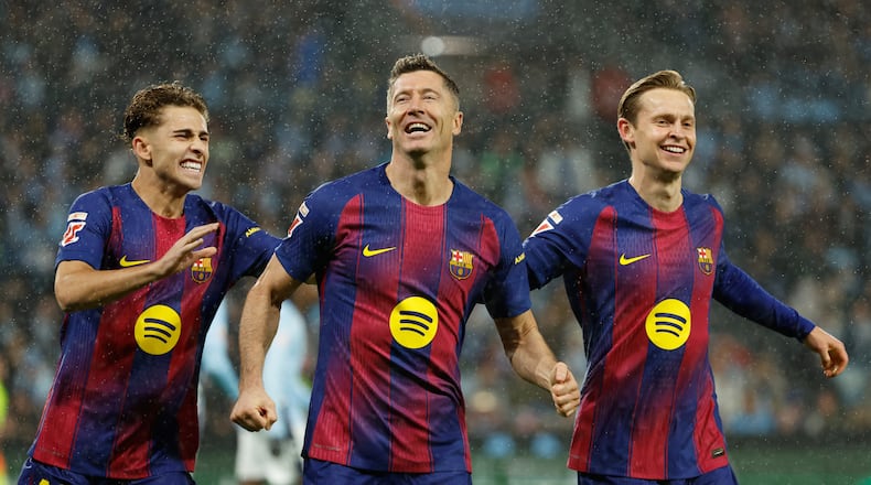Barcelona's Robert Lewandowski, center, celebrates scoring his side's opening goal from the penalty spot during the Spanish La Liga soccer match between Celta Vigo and Barcelona in Vigo, Spain, Sunday, Nov. 9, 2025. (AP Photo/Lalo R. Villar)