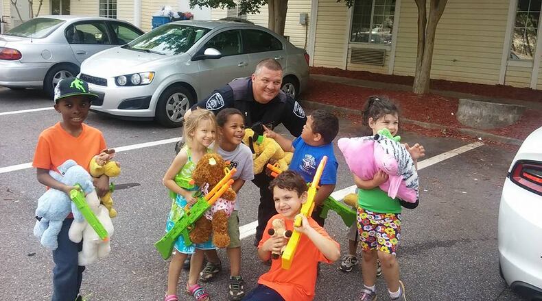 Snellville police Sgt. Scott Smith was recently caught on camera dishing out stuffed animals to a few lucky local kids. (Facebook photo)