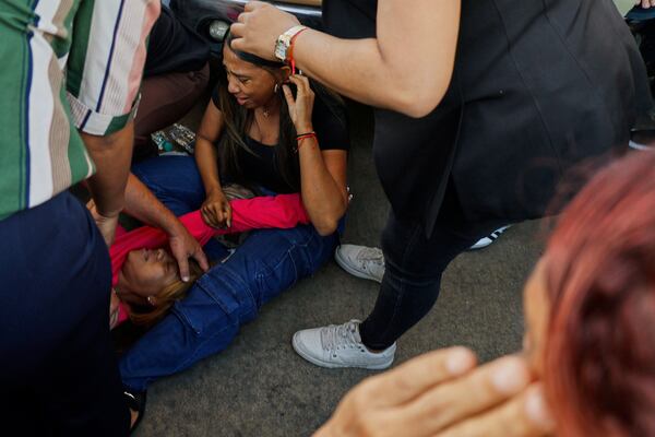 Relatives cry while waiting for news of loved ones outside the Jet Set nightclub after its roof collapsed during a merengue concert in Santo Domingo, Dominican Republic, Tuesday, April 8, 2025. (AP Photo/Eddy Vittini)