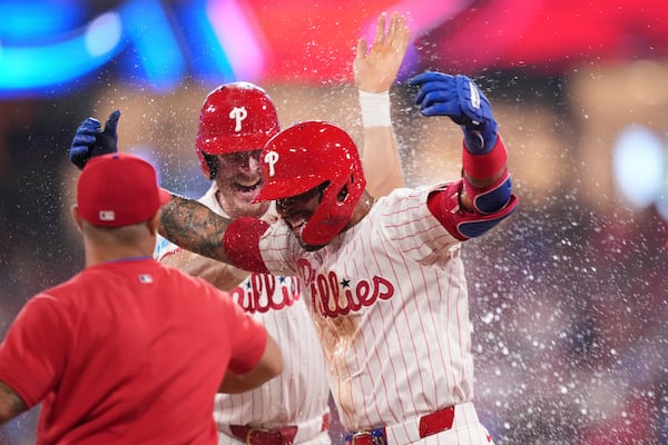 Philadelphia Phillies' Edmundo Sosa, right, celebrates with teammates after the Phillies won a baseball game against the Boston Red Sox on catcher's interference with the bases loaded in the 10th inning Monday, July 21, 2025, in Philadelphia. (AP Photo/Matt Slocum)