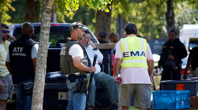 Law enforcement officers gather on the Delta State University campus to search for an active shooter in connection with a the shooting of history professor Ethan Schmidt in his office in Cleveland, Miss., Monday, Sept. 14, 2015. The suspect in the shooting has not yet been identified and remains at large. (AP Photo/Rogelio V. Solis)