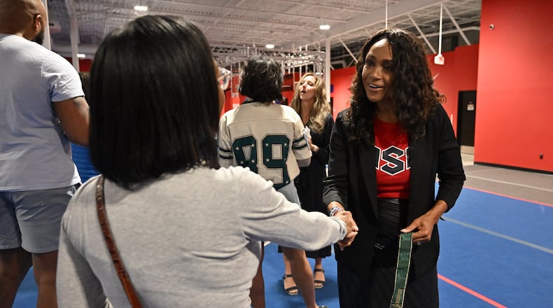 Dominique Dawes (right) is greeted by an influencer Trunae Green during the opening day of Dominique Dawes Academy, Friday, March 6, 2026, in Alpharetta. 1996 Olympics medal winning gymnast Dominique Dawes has seven gymnastics academies in Maryland & Texas and has now expanded to metro Atlanta, in this case, Alpharetta. (Hyosub Shin/AJC)