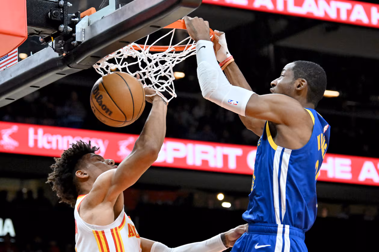 The Atlanta Hawks reportedly have acquired Jonathan Kuminga (right), shown dunking against Jalen Johnson, and Buddy Hield from the Golden State Warriors for center Kristaps Porzingis. (Hyosub Shin/AJC 2024)