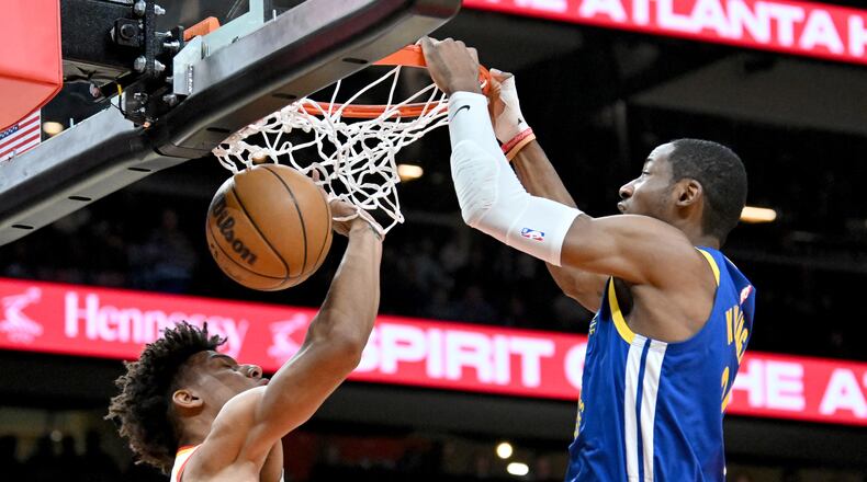 The Atlanta Hawks reportedly have acquired Jonathan Kuminga (right), shown dunking against Jalen Johnson, and Buddy Hield from the Golden State Warriors for center Kristaps Porzingis. (Hyosub Shin/AJC 2024)
