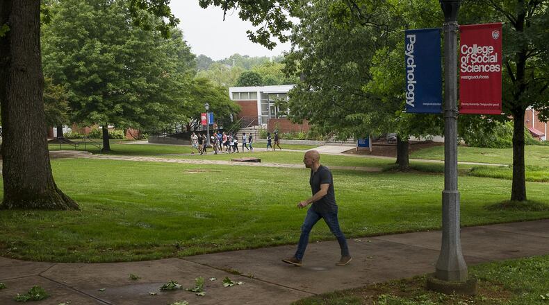 A man walks the campus at the University of West Georgia in Carrollton. The plot of land to the right of the man is where recent archaeological tests suggest slaves from a former plantation might be buried. If true, UWG will be added to a long list of colleges and communities challenged with questions on how to deal with newly discovered remains of former slaves and Reconstruction-era African Americans. (ALYSSA POINTER/ALYSSA.POINTER@AJC.COM)