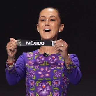 Mexican President Claudia Sheinbaum holds up the team name of Mexico during the draw for the 2026 soccer World Cup at the Kennedy Center in Washington, Friday, Dec. 5, 2025.(AP Photo/Evan Vucci)