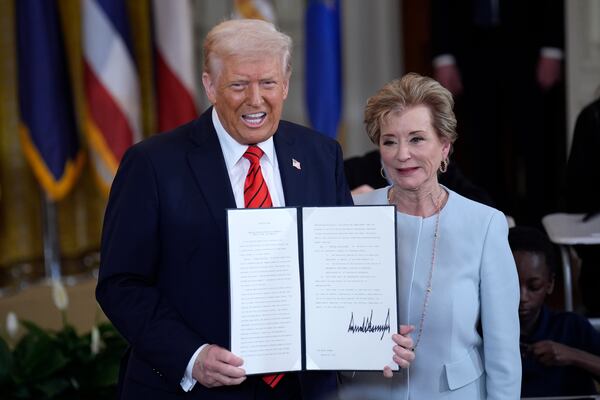 President Donald Trump, with Secretary of Education Linda McMahon, shows his signature after signing an executive order to shut down the Department of Education during an event in the East Room at the White House in Washington, D.C., on Thursday, March 20, 2025. (Yuri Gripas/Abaca Press/TNS)