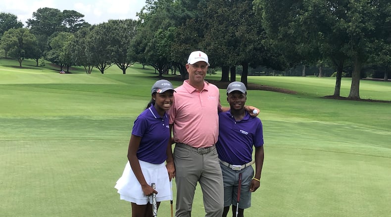 Eight-time PGA Tour winner Stewart Cink celebrates with First Tee of Atlanta representatives Tatum Thompson (L) and Marcus Leonard (R) after they learn of their selection to hit the opening tee shots for the Tour Championship in September.
