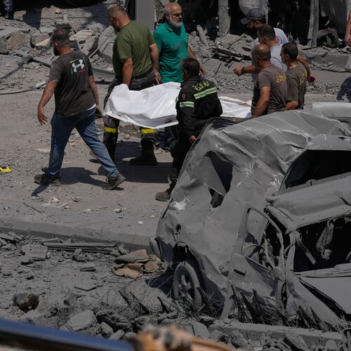 Rescue workers carry a plastic bag, containing the body of a person who was killed at a house that was hit by an Israeli airstrike in Deir al-Zahrani village, southern Lebanon, Saturday, Aug. 15, 2026. (AP Photo/Mohammed Zaatari)